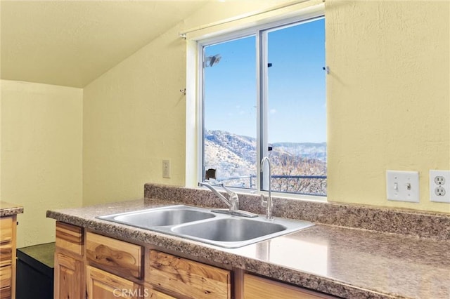 kitchen featuring a mountain view, sink, and lofted ceiling