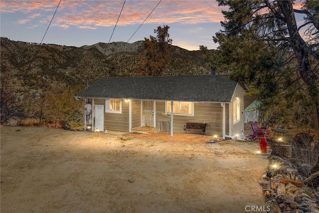 single story home featuring roof with shingles and a mountain view