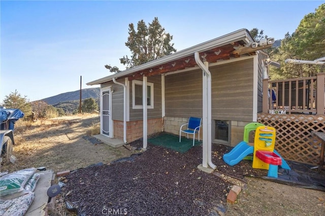 view of side of home featuring a playground and a mountain view