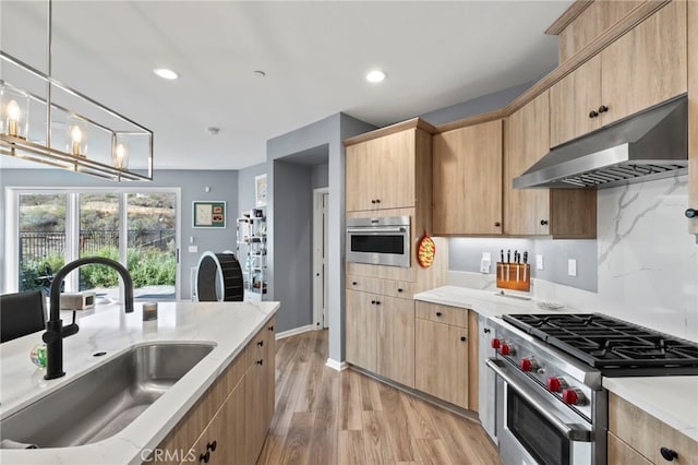 kitchen featuring light brown cabinetry, stainless steel appliances, pendant lighting, and sink