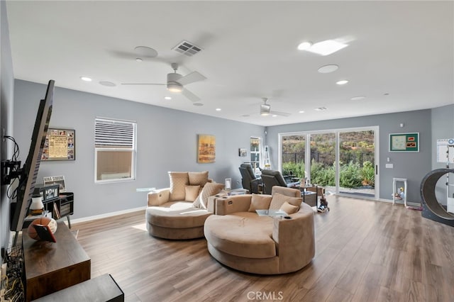 living room with ceiling fan and light hardwood / wood-style flooring