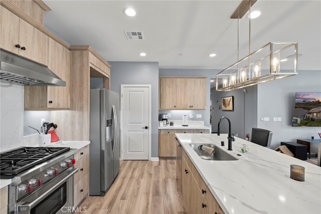 kitchen with sink, hanging light fixtures, appliances with stainless steel finishes, and light brown cabinets