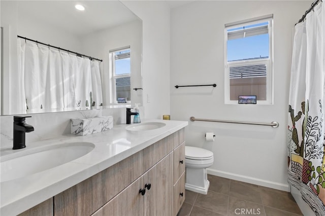 bathroom with toilet, vanity, and tile patterned flooring