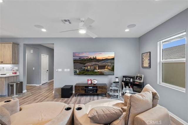 living room featuring ceiling fan and light hardwood / wood-style flooring