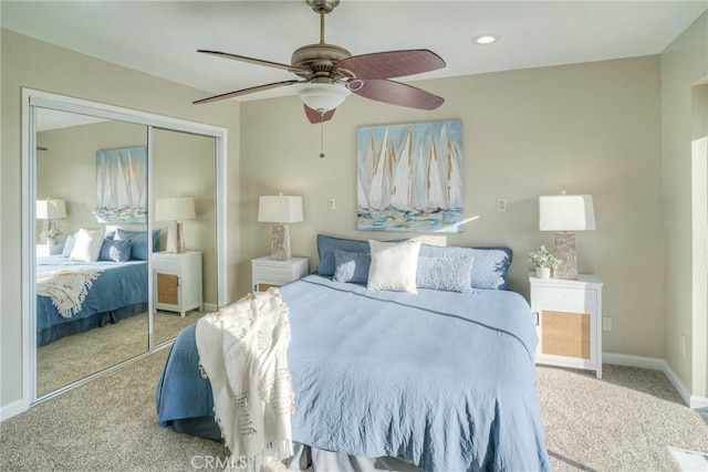 bedroom with ceiling fan, light colored carpet, and a closet