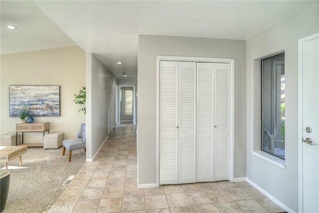 hall with light colored carpet