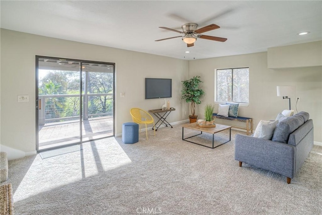 carpeted living room featuring ceiling fan