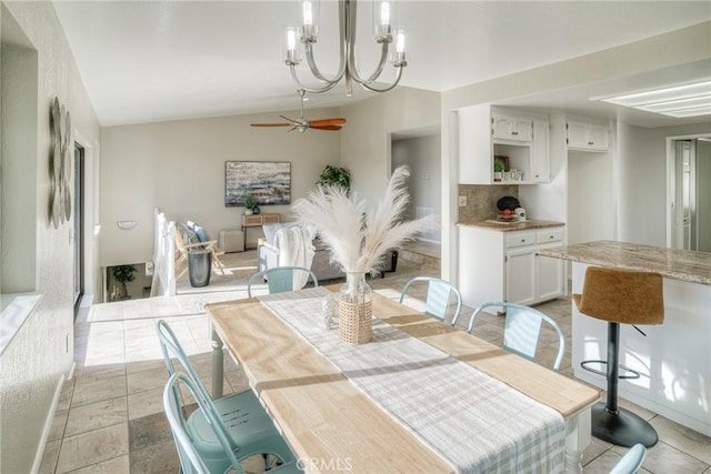 dining room with vaulted ceiling, ceiling fan with notable chandelier, and light tile patterned floors