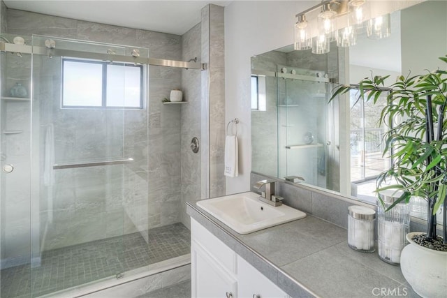 bathroom with an enclosed shower, vanity, and plenty of natural light