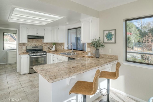 kitchen featuring white cabinetry, sink, stainless steel gas range, and kitchen peninsula