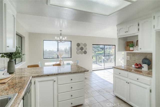 kitchen with pendant lighting, kitchen peninsula, and white cabinets