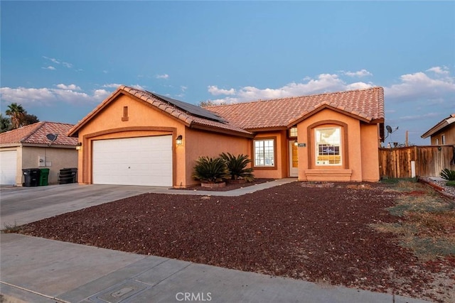 view of front of property featuring a garage and solar panels