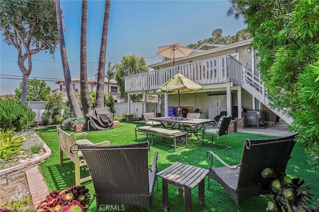 back of property featuring central AC, a wooden deck, and a lawn