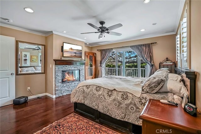 bedroom with crown molding, a stone fireplace, hardwood / wood-style floors, and access to outside