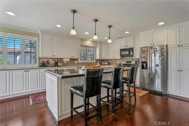 kitchen with white cabinetry, hanging light fixtures, stainless steel fridge with ice dispenser, and a kitchen island