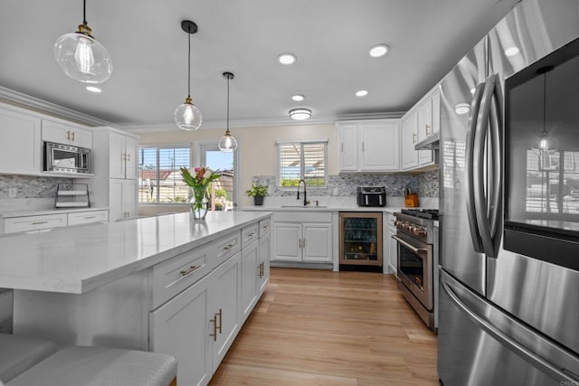 kitchen featuring white cabinetry, appliances with stainless steel finishes, a healthy amount of sunlight, tasteful backsplash, and pendant lighting