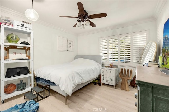 bedroom featuring crown molding, light wood-style flooring, and ceiling fan