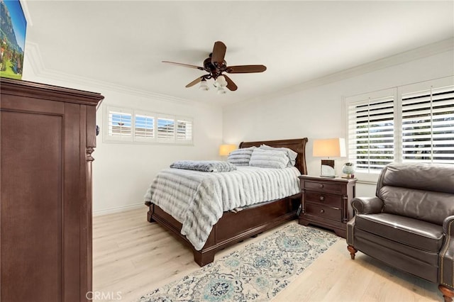 bedroom featuring ornamental molding, multiple windows, and light wood-style flooring