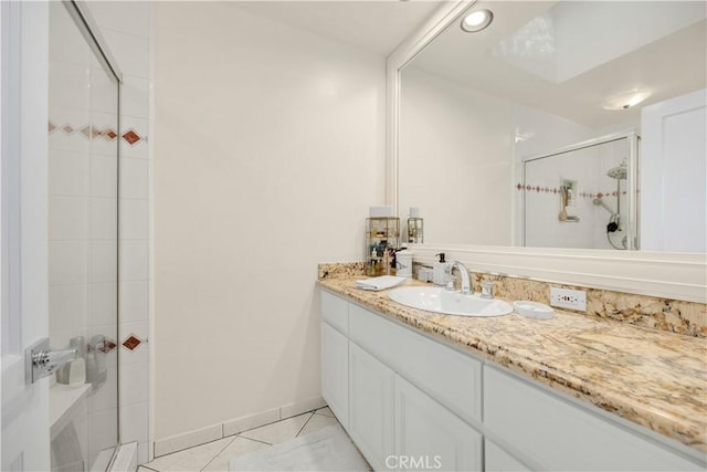 bathroom featuring a shower stall, baseboards, and vanity