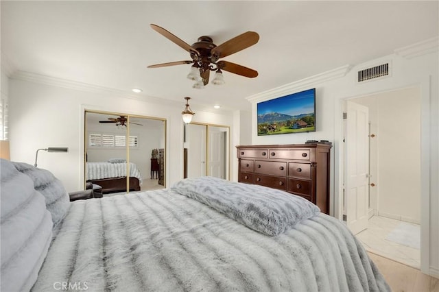 bedroom with visible vents, a ceiling fan, crown molding, multiple closets, and recessed lighting