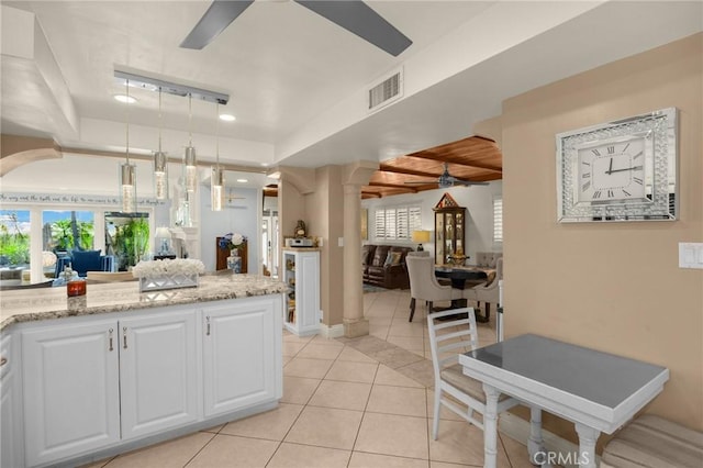 kitchen with visible vents, white cabinets, a ceiling fan, light stone counters, and pendant lighting