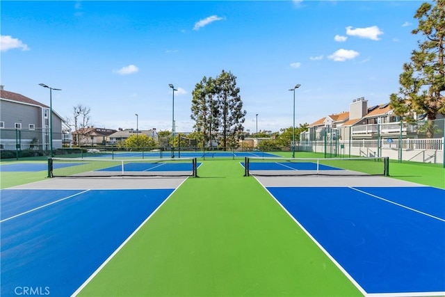 view of sport court with a residential view, community basketball court, and fence