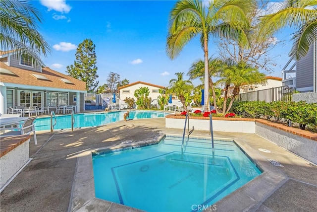 view of swimming pool with a hot tub and a patio