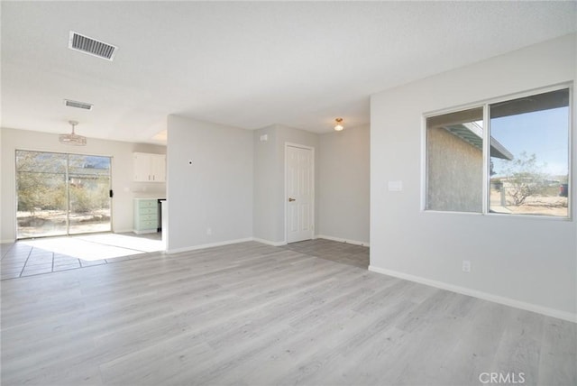 6213 Baileya Ave Unit 29, Palms, CA 92277 - unfurnished living room with light wood finished floors, baseboards, and visible vents