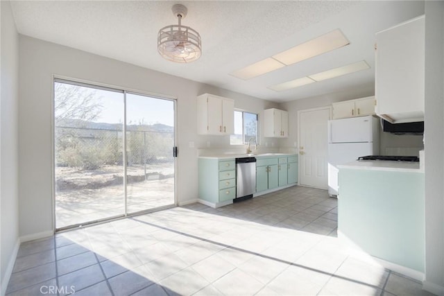 kitchen with a sink, stainless steel dishwasher, white cabinets, light countertops, and baseboards