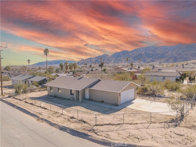 6213 Baileya Ave Unit 29, Palms, CA 92277 - view of front of home featuring concrete driveway, a residential view, fence private yard, a mountain view, and an attached garage