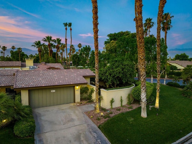 view of front of property with a garage and a yard