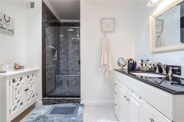 bathroom featuring tile patterned floors, a shower with door, crown molding, and vanity