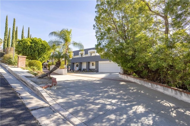 view of property hidden behind natural elements featuring a garage