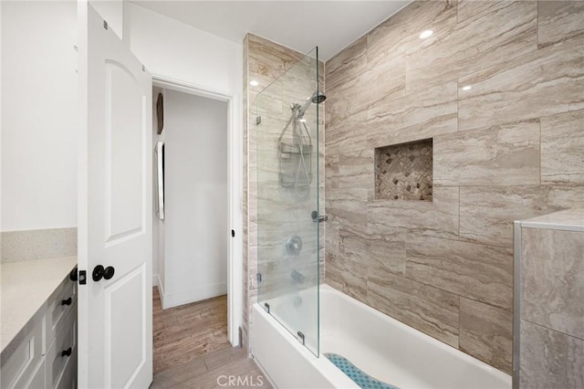 bathroom with tiled shower / bath combo and vanity