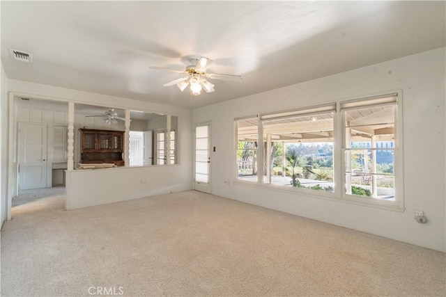 unfurnished living room with ceiling fan and light colored carpet