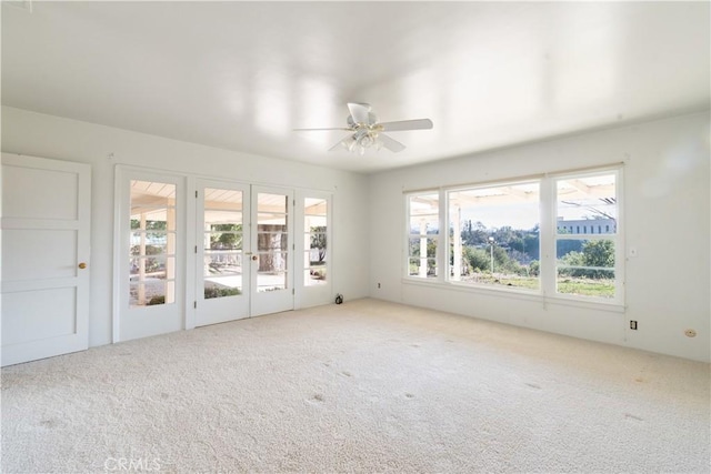 spare room with ceiling fan, french doors, and carpet flooring