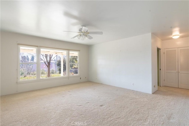 carpeted empty room featuring ceiling fan and plenty of natural light