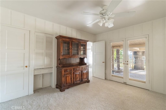 interior space with ceiling fan, light colored carpet, and french doors