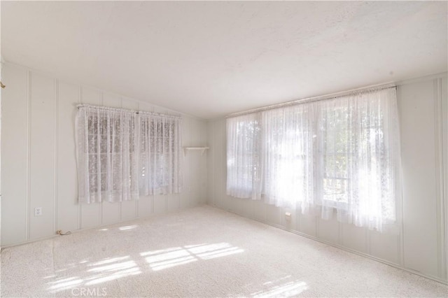 spare room featuring vaulted ceiling and carpet