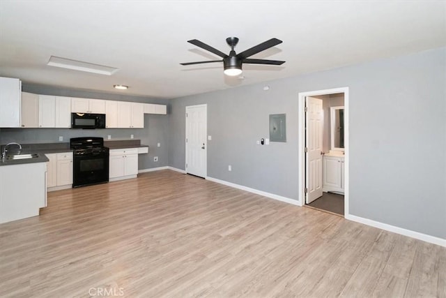 kitchen featuring black appliances, white cabinetry, sink, light wood-type flooring, and electric panel