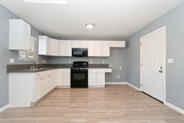 kitchen featuring black appliances, white cabinets, sink, and light hardwood / wood-style flooring