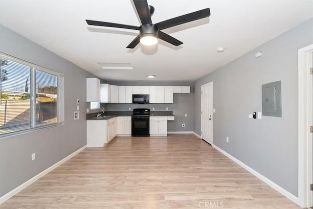 kitchen with electric panel, black appliances, sink, light hardwood / wood-style flooring, and white cabinets