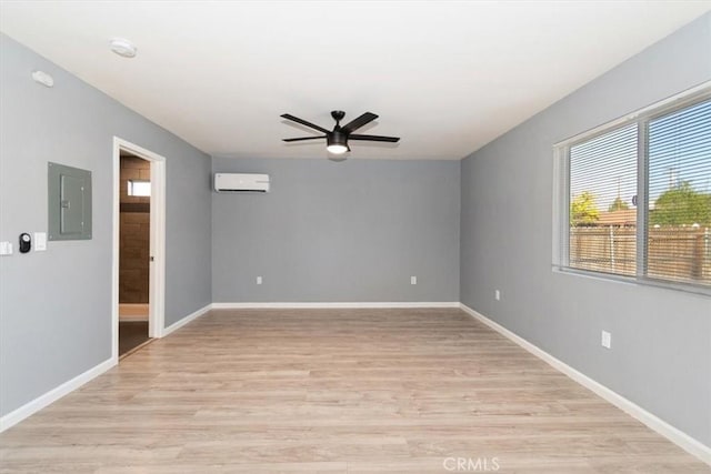 empty room with ceiling fan, light hardwood / wood-style flooring, a wall unit AC, and electric panel