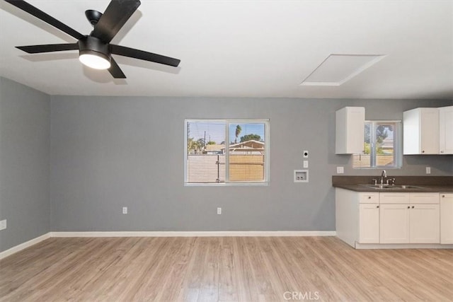 kitchen with sink, white cabinetry, light hardwood / wood-style flooring, and a wealth of natural light