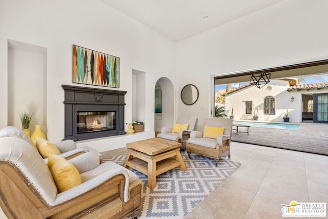 living room with light tile patterned floors and a towering ceiling