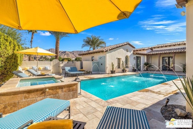 view of swimming pool with an in ground hot tub, pool water feature, and a patio