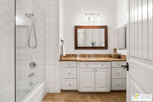 bathroom featuring tiled shower / bath combo and vanity