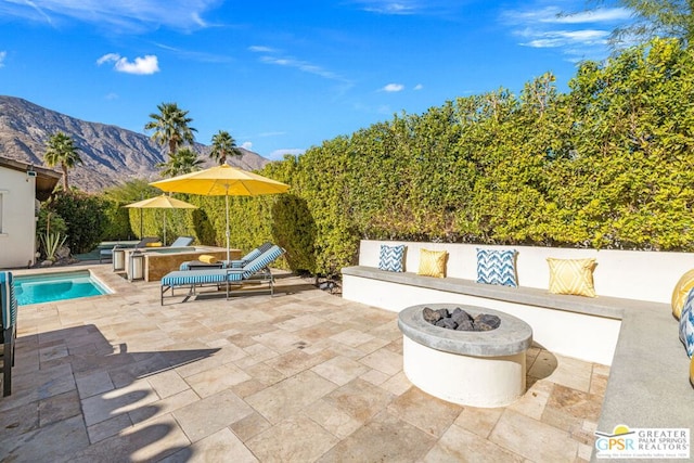 view of patio / terrace featuring a mountain view and a fire pit