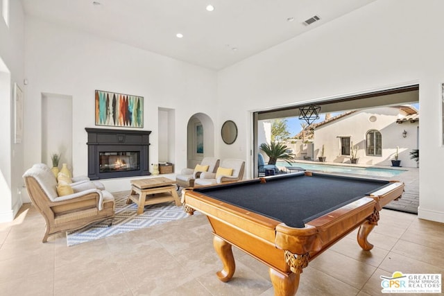 playroom featuring light tile patterned flooring, pool table, and a towering ceiling