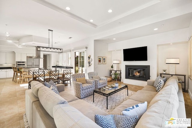 living room featuring a raised ceiling and light tile patterned floors